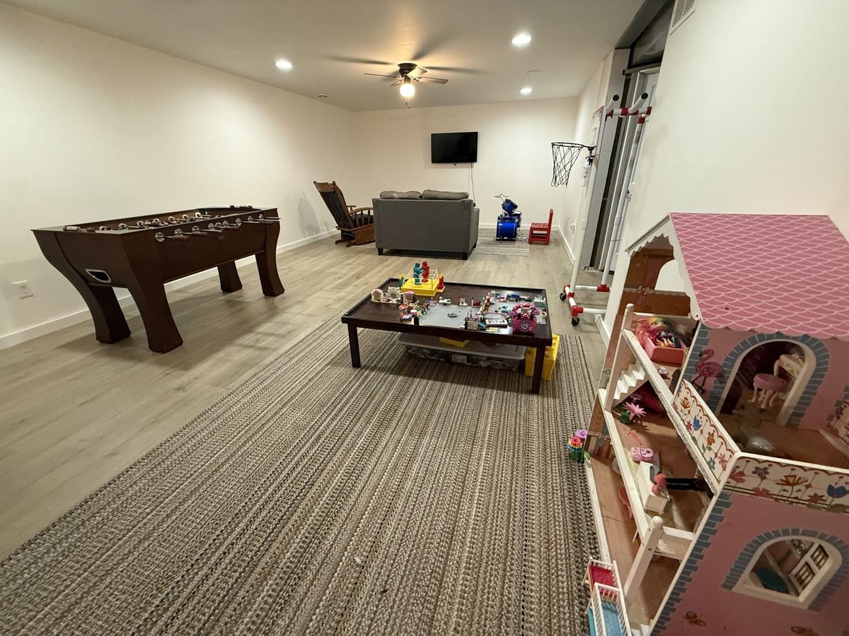 Basement living room with foosball table, TV and play area