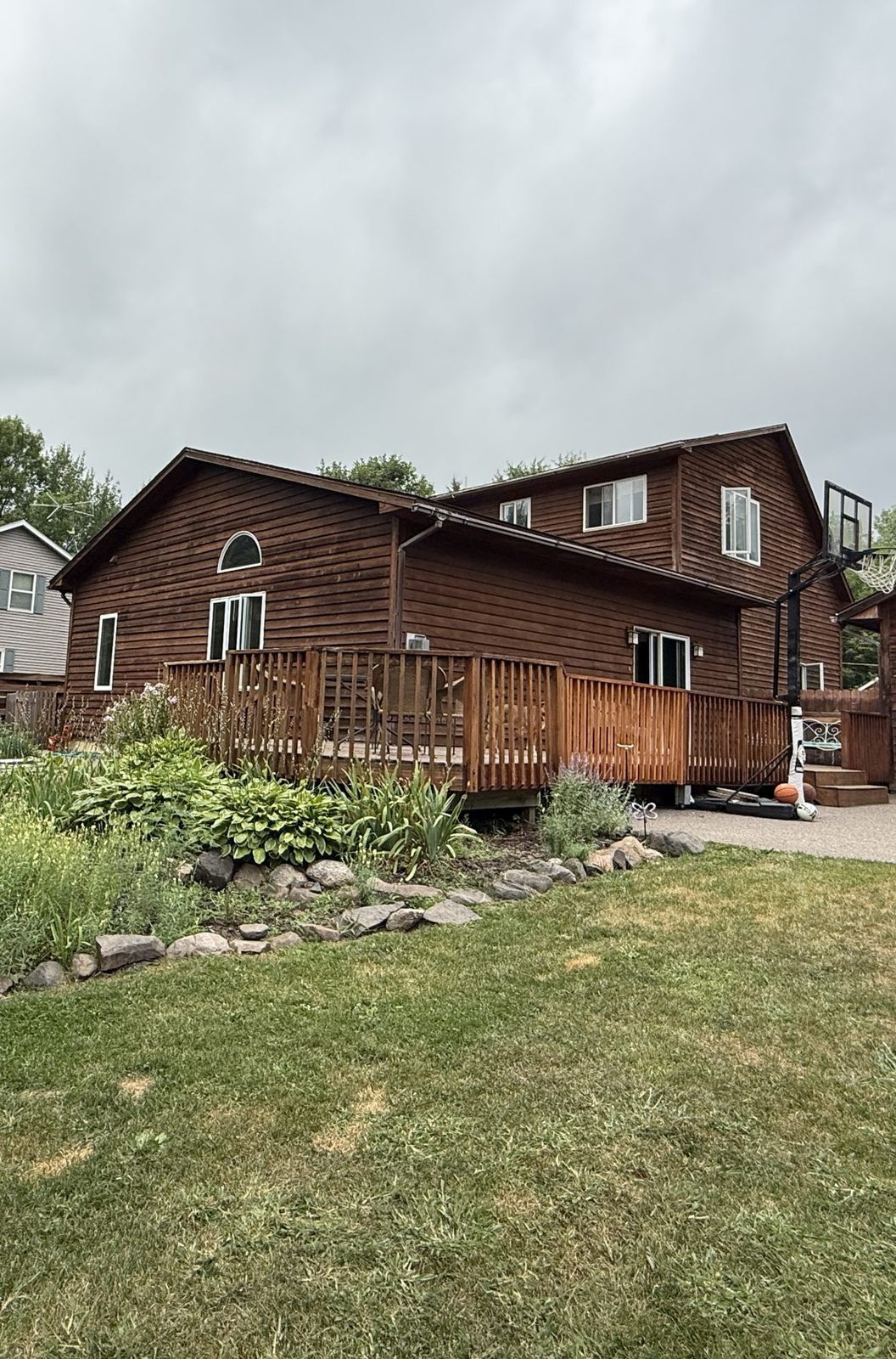 Back of The Pine City House with deck, gardens and big lawn