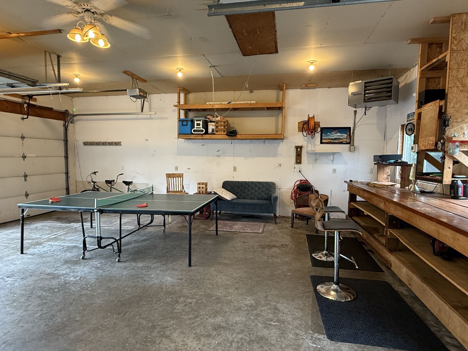 Garage game space with ping-pong table and bar seating at The Pine City House