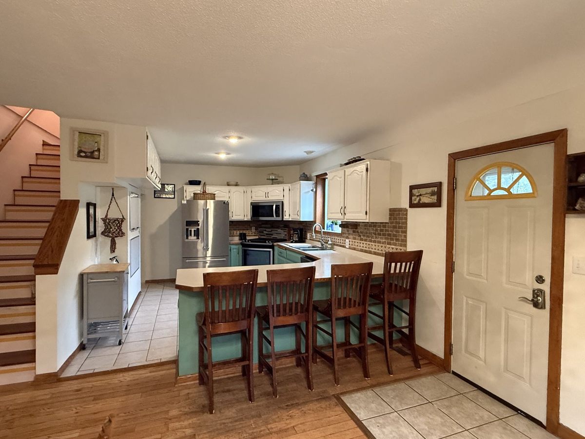 Full kitchen with breakfast bar seating at The Pine City House