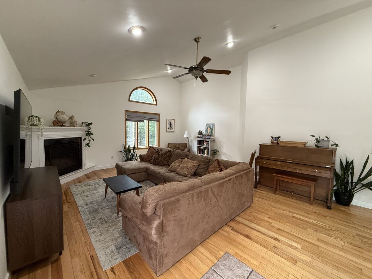 Living room with vaulted ceilings, piano and fireplace